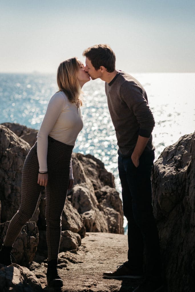 Il y a un couple qui s'embrasse devant la mer